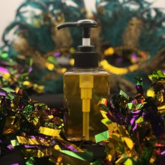 bottle of body oil centered around mardi gras paraphenalia